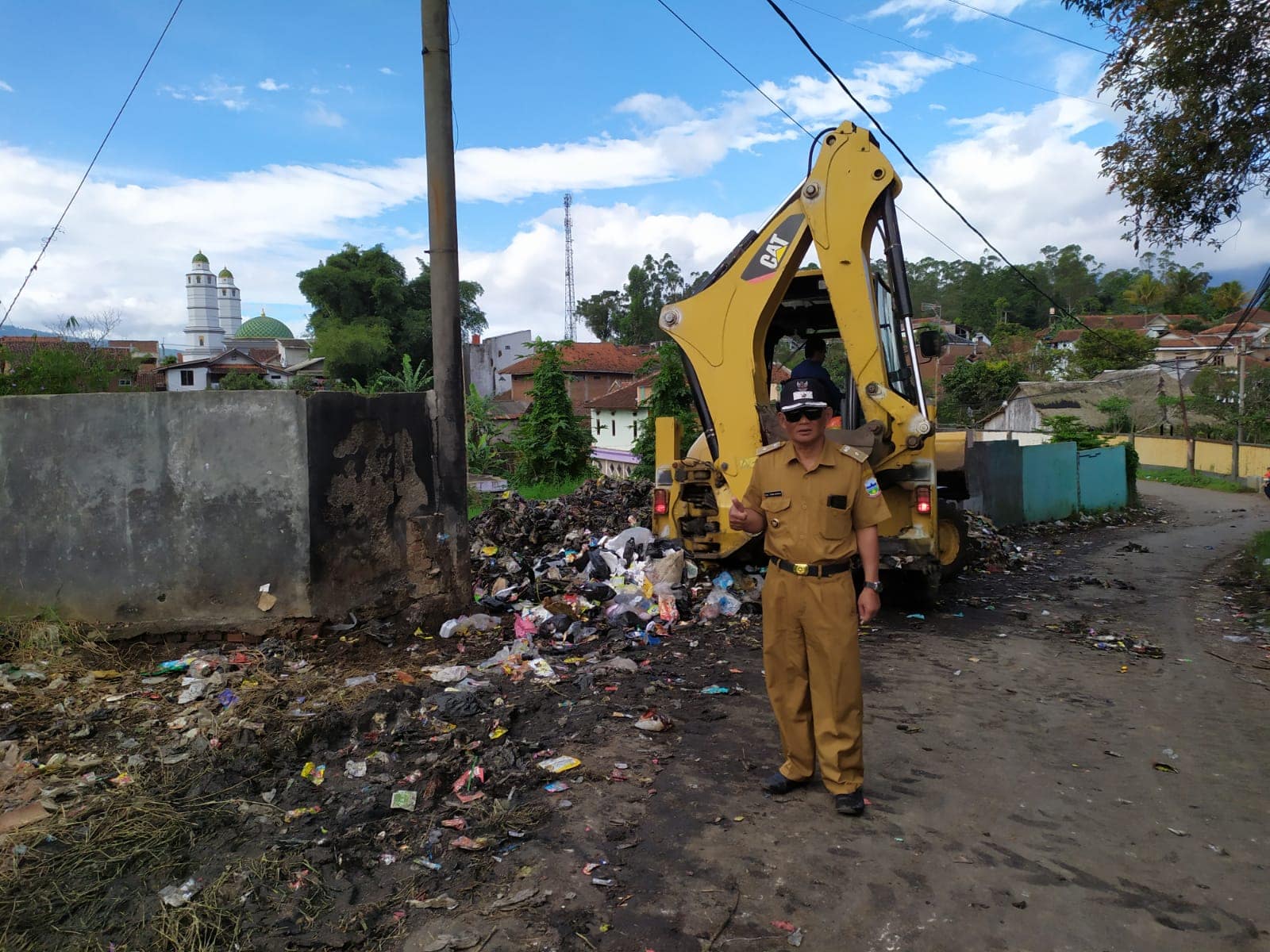 Drs. Tomi Romli Kades Samarang mengeruk sampah dengan alat berat Drs. Tomi Romli Kades Samarang mengeruk sampah dengan alat berat